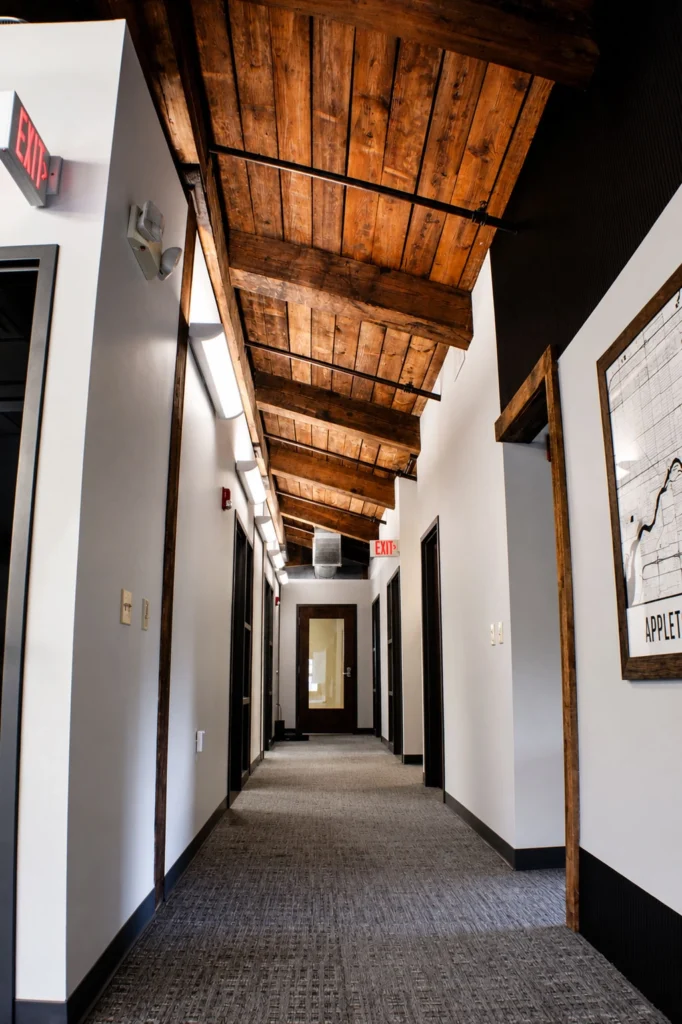 Interior hallway at Capital Data showcasing vaulted wood ceilings, exposed beams, modern office entrances, and industrial-inspired architectural finishes.