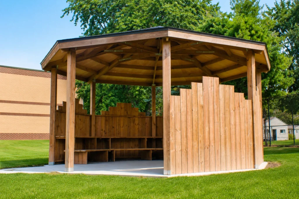 Appleton Area School District Ferber Elementary PTO outdoor classroom with covered pavilion, built-in seating, and decorative wood privacy walls designed for outdoor learning.