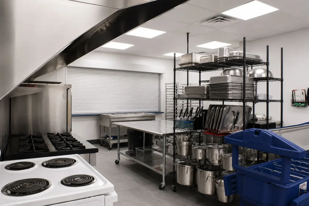 Commercial kitchen at St. Peter's Lutheran School with stainless steel worktables, organized storage racks, and updated food preparation areas designed for efficient meal service.