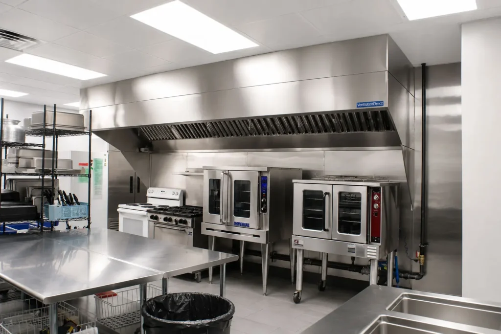 Renovated school kitchen at St. Peter's Lutheran School featuring commercial ovens, ventilation systems, stainless steel surfaces, and modern equipment supporting daily meal preparation for students.